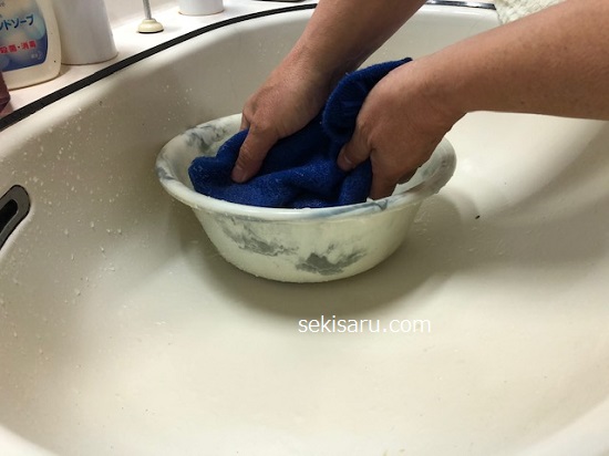アクリル素材の帽子を洗面器の中に浸す