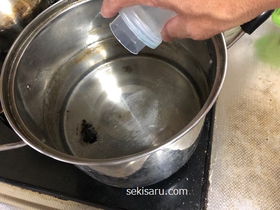 真水が溜まった鍋の中に洗剤を入れる