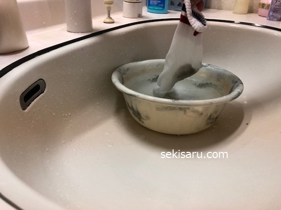 ハイドロハイターを加えたぬるま湯が入った洗面器の中に靴下を入れる