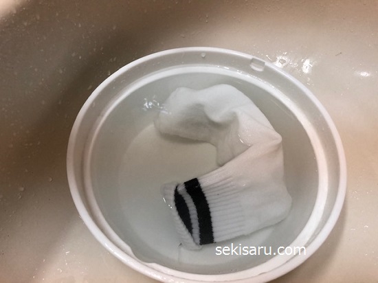 靴下をお湯が入った洗面器の中で浸けおきする