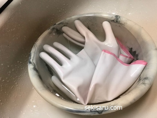 柔軟剤を加えたぬるま湯の中でゴム手袋を浸けおきする