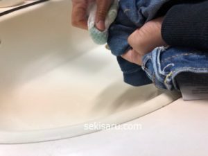 スポンジでジーンズを拭く